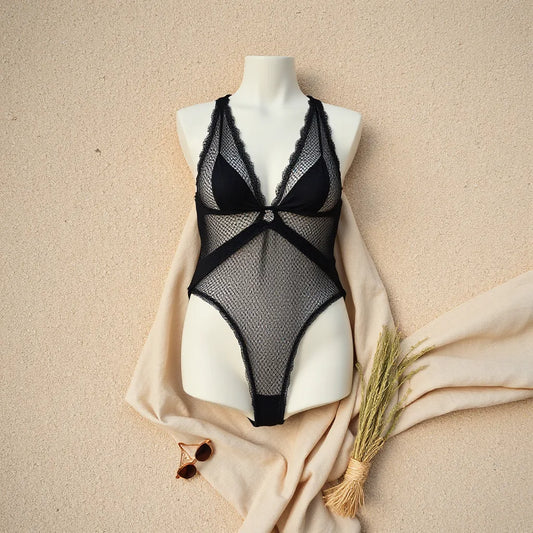 Luxurious mesh one-piece swimsuit displayed on a minimal mannequin with soft coastal styling.